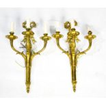 A pair of French gilt brass wall lights, each composed of three branches, and bow top to the back
