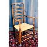 A 19th century ladder back oak armchair with rush woven seat.