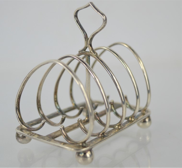 A silver Art Nouveau toast rack, London 1909, bun feet.