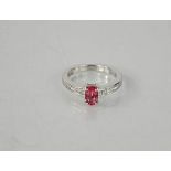 An 18ct white gold oval pink spinel and diamond ring, the princess cut diamonds set to the