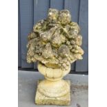 An antique reconstituted stone garden sculpture, fruiting urn on pedestal base, 63cm high.