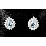 An 18ct white gold pear shape aquamarine earrings, approximately 1ct each surrounded by diamonds