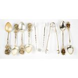 A group of silver and white metal spoons, a silver pair of sugar tongs, and a Mappin & Webb pair