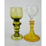 Two German glass Romer wine glasses, one in green, the other in yellow with etched decoration,