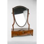 A Regency mahogany toilet mirror, with shield form mirror, and the bow front having three drawers,