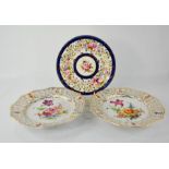 A pair of porcelain Dresden style plates depicting flowers, and a further porcelain plate.