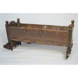 A 17th century oak cradle with rope string base , ball finials and shaped rockers