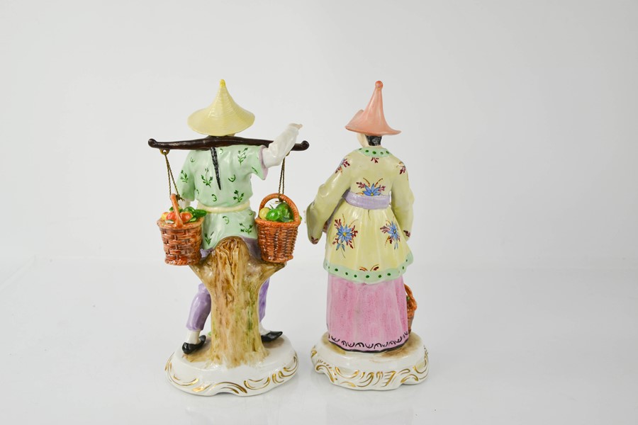 A pair of 19th century Sitzendorf oriental figures carrying baskets of fruit, 24cm high. - Image 2 of 2