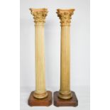 A 19th century pair of architectural fluted columns with corinthian capitals, raised on mahogany