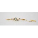 A 9ct gold and aquamarine set bar brooch with safety chain.