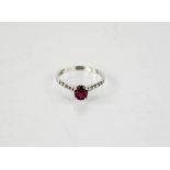 A 14ct diamond and ruby ring, the ruby approximately 1ct, with diamond set shoulders, size M, 1.7g.