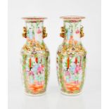 A pair of 19th century Chinese canton vases, enamelled with figural cartouches on a floral and