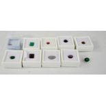 A quantity of loose gemstones to include 2 emeralds, 2 rubies, an orange topaz, an opal and others