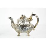 A Victorian silver teapot with embossed decoration, and flower finial, raised on four scroll feet,