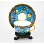 A fine 19th century cup and saucer, with flowers enamelled on a blue ground, with presentation