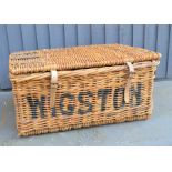 A Wicker laundry basket with leather straps marked Laundry Wigston 663