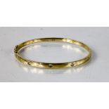 A 14ct yellow gold [tested] diamond set bangle five diamonds, total diamond weight 0.50ct, 15.9g