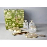 An eight piece white metal dressing table set, comprising pair of cut glass flagons, powder bowl,