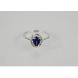 A 9ct white gold and oval sapphire ring, approximately 1ct, surrounded by diamonds, size M, 1.6g.