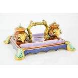 A 19th century Majolica inkstand, the two inkwells with original covers, modelled with rams heads