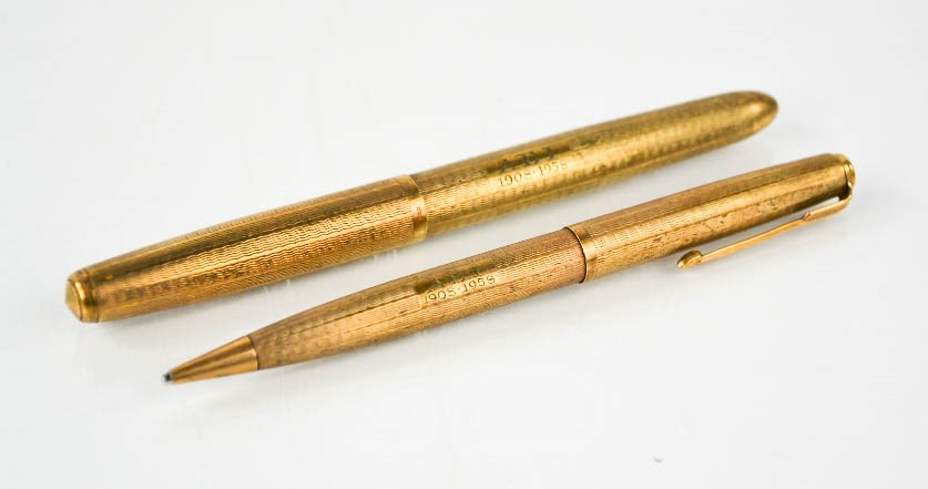 A pair of 9ct gold parker pens, engraved with initials AEI and dated 1908-1958, 51.7g.