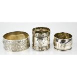 A silver Charles Horner bangle, engraved with chased decoration, together with two silver napkin