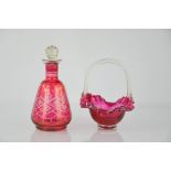 A cranberry glass basket and bottle with stopper.