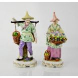 A pair of 19th century Sitzendorf oriental figures carrying baskets of fruit, 24cm high.