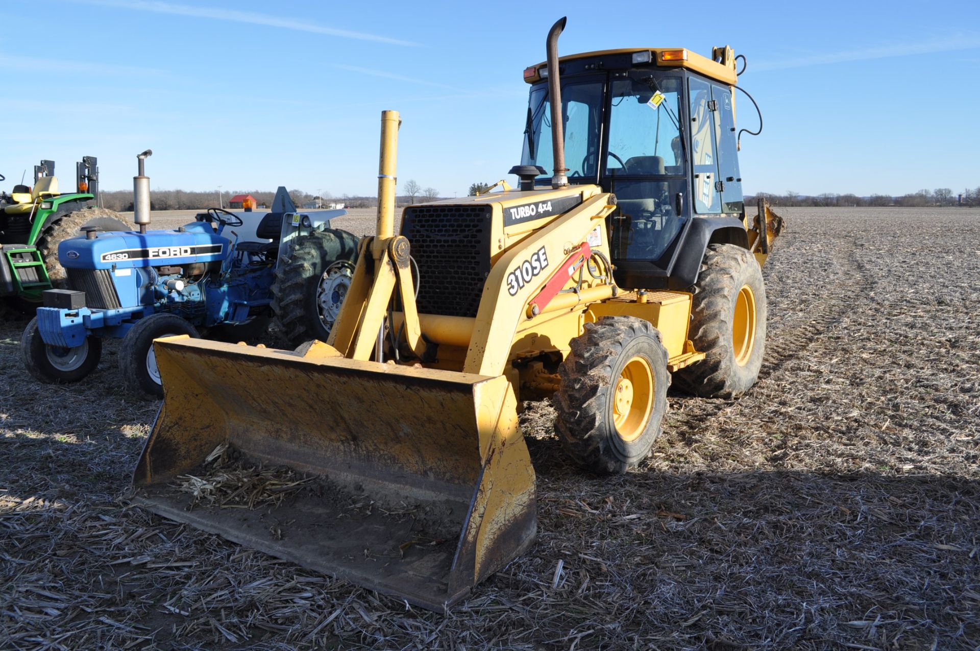 John Deere 310SE Backhoe, 4X4, Cab, heat, rubber and steel outriggers, sells with 24 inch WB Bucket,