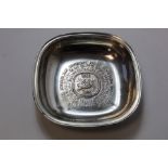 Silver dish of rounded rectangular form with embossed Nestle motif and International inscription.