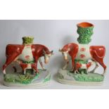Two Staffordshire pottery spill vases in the form of a cow and calf on naturalistic plinth base with