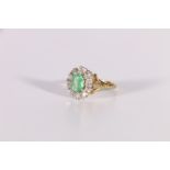 Diamond and emerald oval cluster ring in 18ct gold, 1975. Size 'S½'.