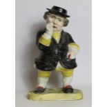 19th century pottery figure of a man taking snuff, standing on a kidney shaped plinth base,