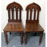 Pair of mahogany hall chairs each on turned supports.