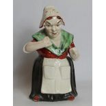 19th century pottery figure of a woman taking snuff, decorated in polychrome, 28cm high.