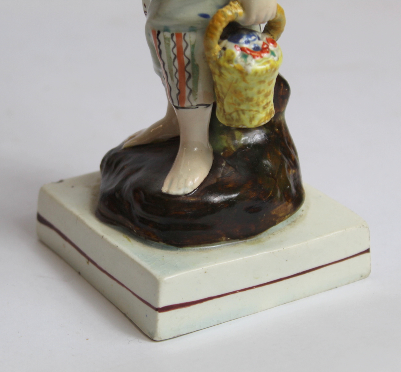 19th century pearlware figure of a farm girl carrying a basket of flowers, on square plinth base - Image 5 of 8