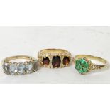 Garnet three stone ring, another five stone with aquamarines and an emerald cluster ring all 9ct