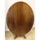 19th century oval tilt top breakfast table on four turned columns and carved downswept supports.