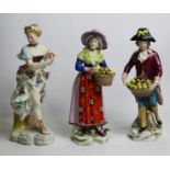 Two continental porcelain figures of fruit sellers, each holding a basket of apples, each 21cm