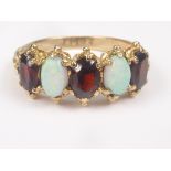 Garnet and opal five stone ring in 9ct gold, 1973. Size 'O½'.