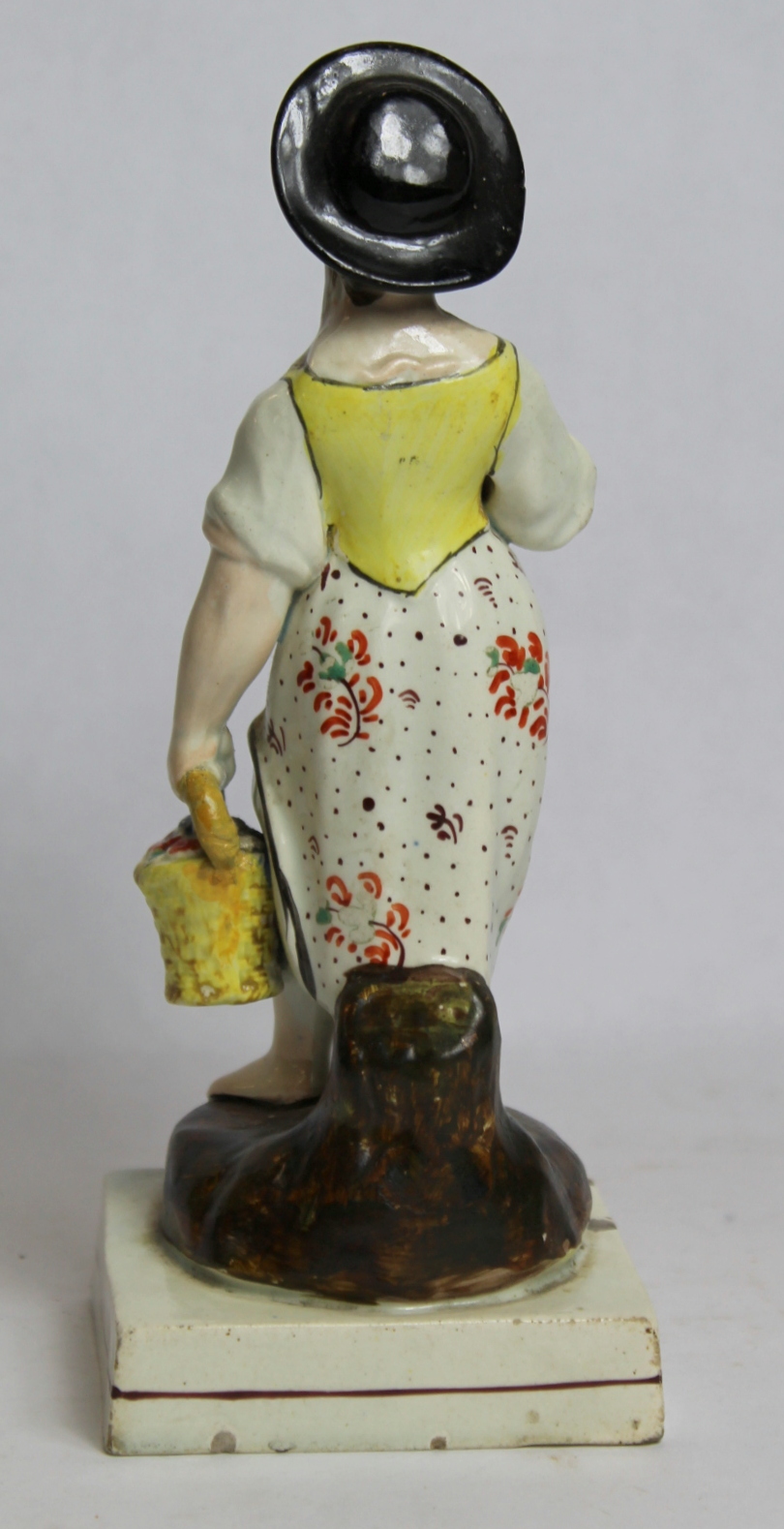 19th century pearlware figure of a farm girl carrying a basket of flowers, on square plinth base - Image 3 of 8