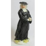 Early 19th century porcelain figure of a vicar standing on a floral plinth base decorated in