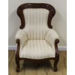 Victorian style upholstered open armchair with carved frame on scroll supports.