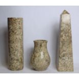 Beige fossil marble obelisk, 30cm high and two matching vases, one of cylindrical form, 25.5cm