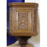 Carved oak corner cabinet enclosed by profusely carved door with shelf below. 97cm.