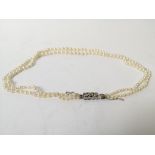 Two row necklace of graduated pearls, on diamond set snap.