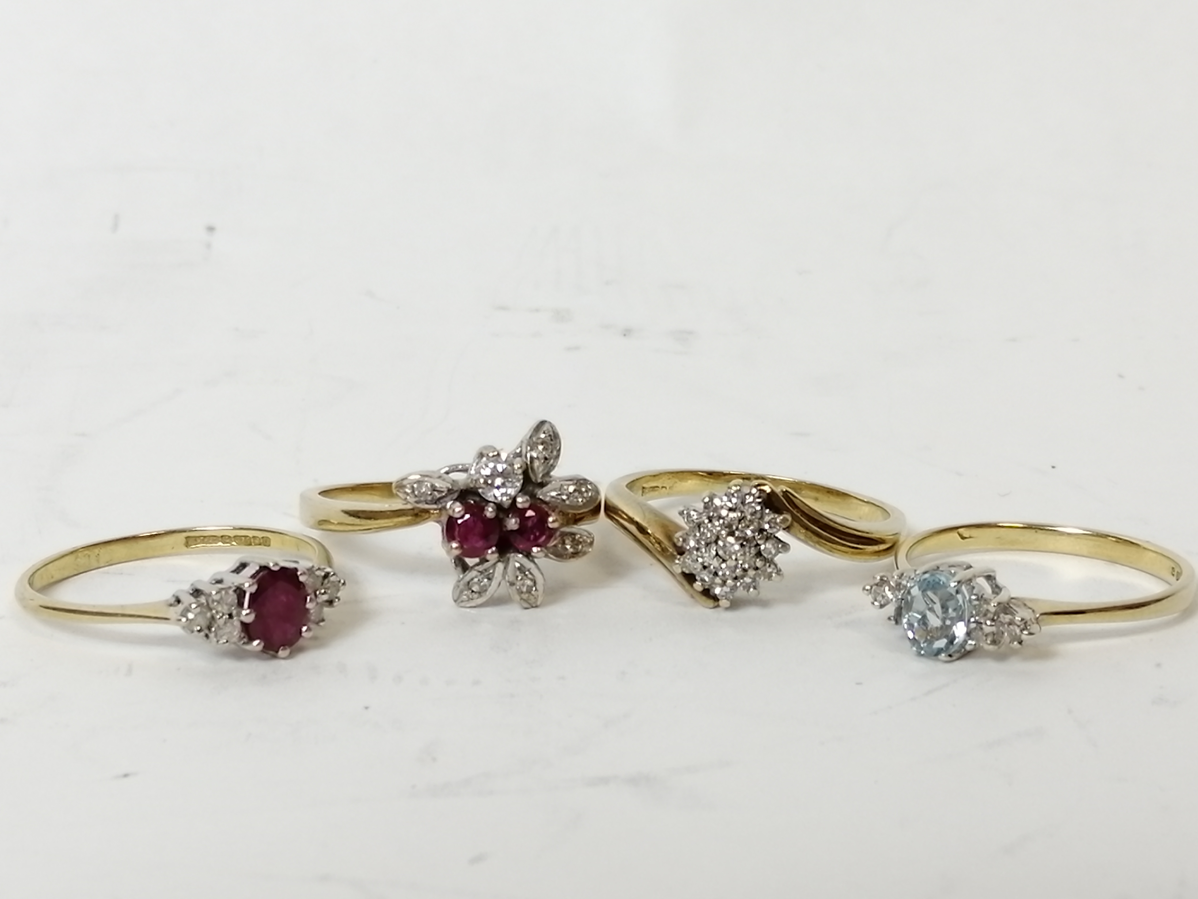 Two ruby and diamond rings, a diamond cluster ring and an aquamarine and diamond ring, all 9ct gold.