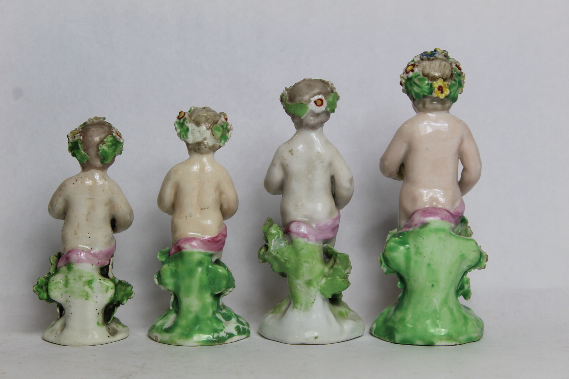 Seven 18th century Derby porcelain small figures of putti holding baskets of flowers, all with patch - Image 3 of 9