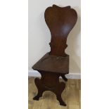 Victorian oak hall chair with shield shaped back and solid seat on turned supports.