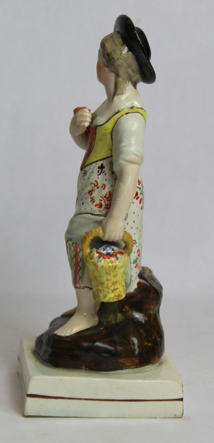 19th century pearlware figure of a farm girl carrying a basket of flowers, on square plinth base - Image 4 of 8